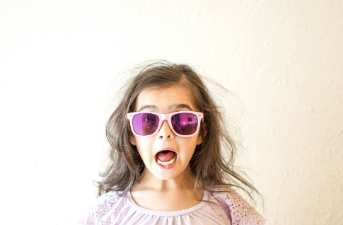 Surprised little girl with sunglasses on.