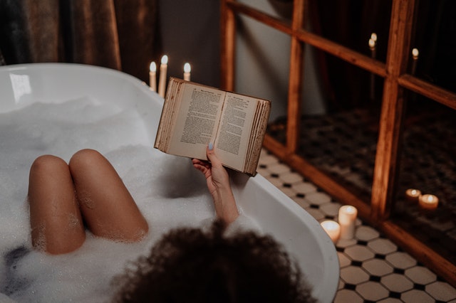 Person reading a book in a bubble bath