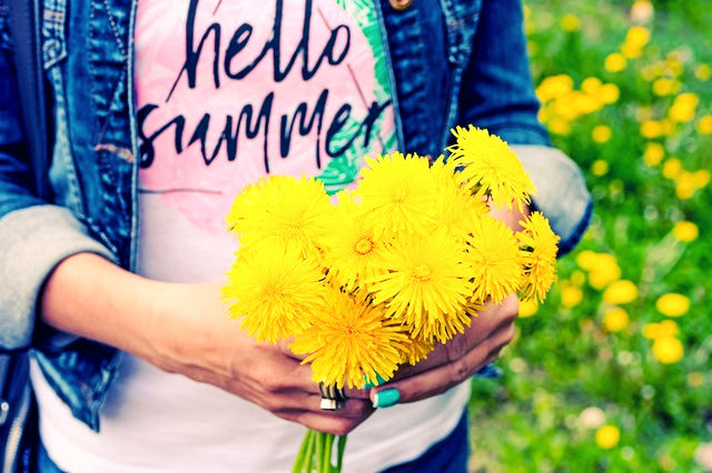 person holding yellow daisies outside